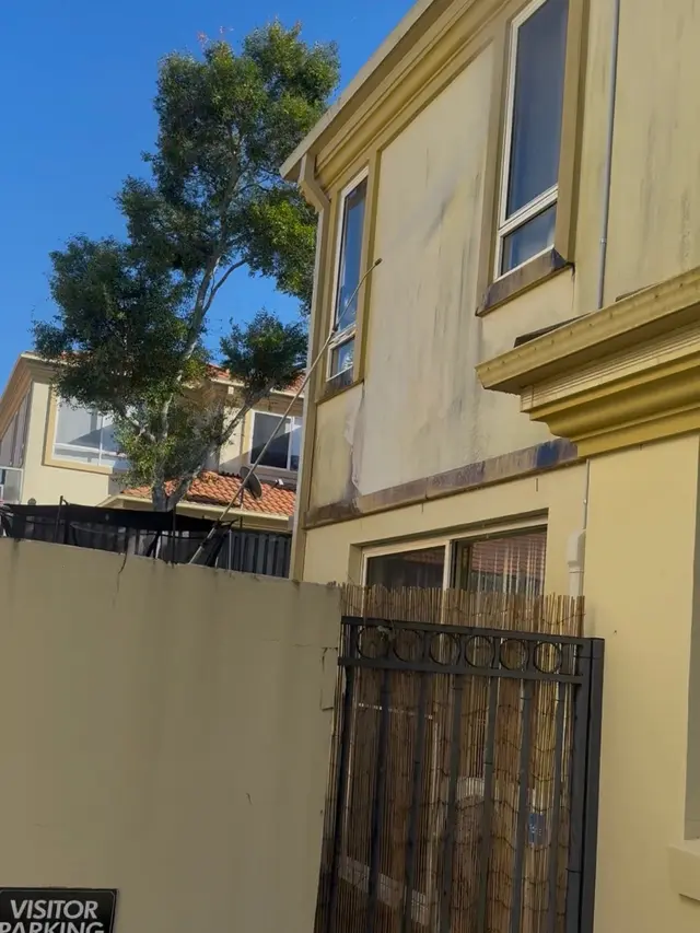 Weathered, stained side wall of a townhouse before repainting