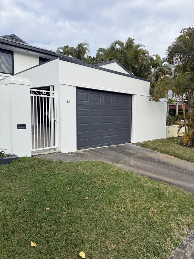 The same home repainted in soft off white with dark charcoal fascias, trims and garage door