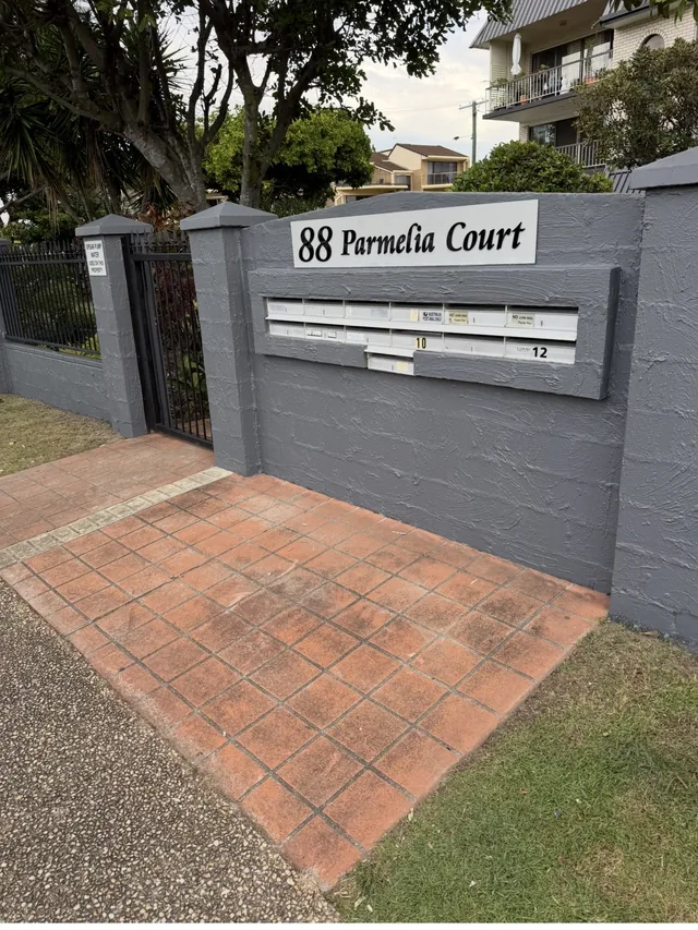 The same boundary wall and letterbox surround repainted in charcoal grey